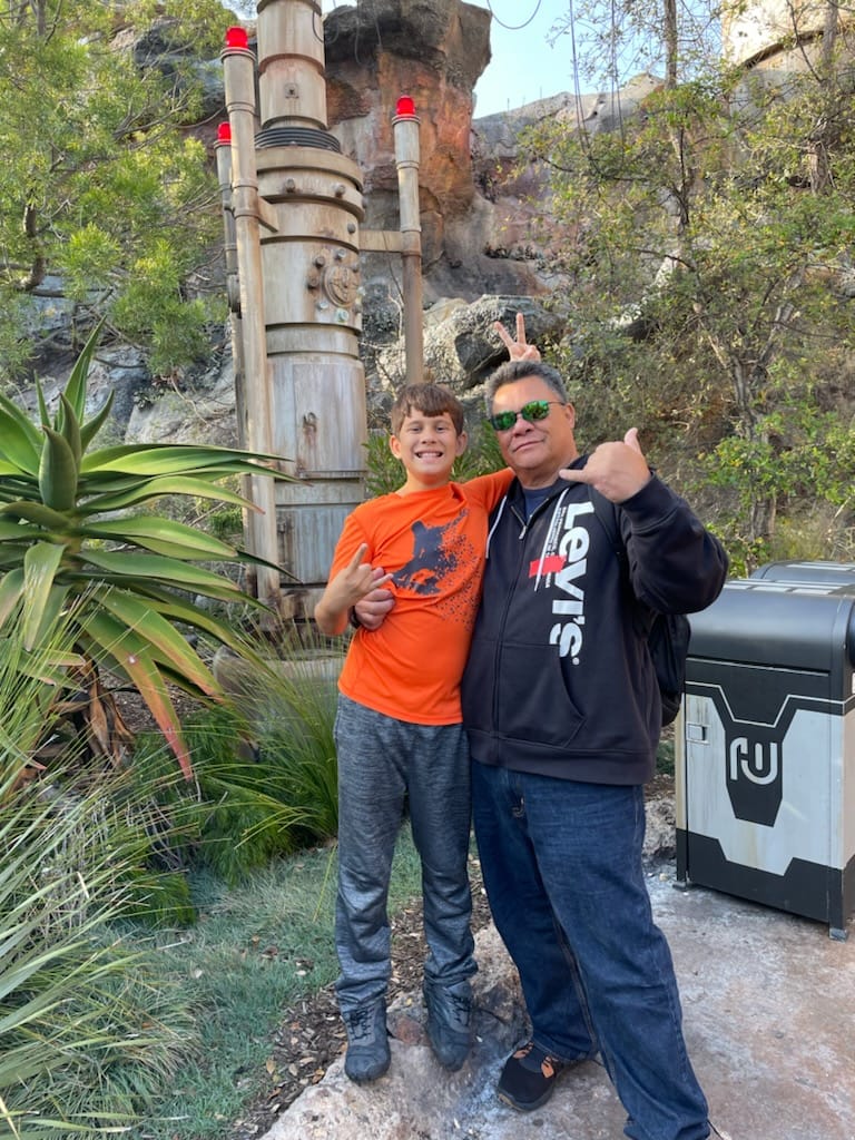grandson and grandfather standing in star wars land disneyland